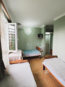 a room with three beds and a window at Ureki House in Ureki +15 photos
