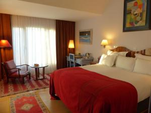 una camera d'albergo con un grande letto con una coperta rossa di La Villa Mandarine a Rabat