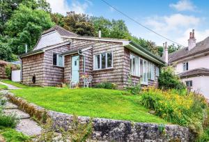 ein kleines Haus mit Rasen davor in der Unterkunft Little Winters Cottage in Lyme Regis