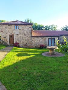 a stone house with a bench in the yard at REMANSO DE TRASFONTAO "Casa do Campo" in Silleda