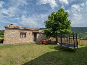 uma casa de pedra com um trampolim no quintal em eva y maría CASA RURAL em Rañín