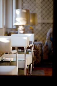 um quarto com duas cadeiras e uma mesa com um candeeiro em SL Hotel Santa Luzia – Elvas em Elvas
