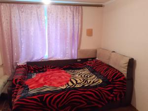 uma cama num quarto com um cobertor de zebra em Татьянин двор em Kamianets-Podilskyi