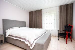 - une chambre avec un grand lit et une chaise noire dans l'établissement Lakeview beach apartment in Viljandi, à Viljandi