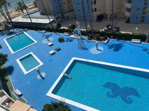una vista aérea de una gran piscina azul en SERVICE APART LAZARO- Apartamentos Aguamarina 57, en Calpe