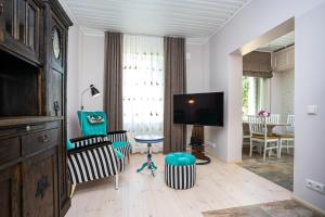 - un salon avec une télévision, une chaise et une table dans l'établissement Lakeview beach apartment in Viljandi, à Viljandi