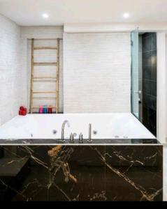 a bathroom with a large bath tub with a sink at Romantic Jacuzzi Apartment in Athens