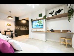a living room with a couch and a tv on the wall at Romantic Jacuzzi Apartment in Athens