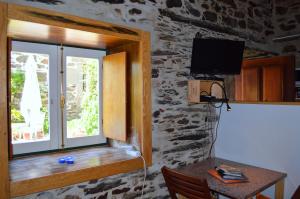 ein Fenster in einem Zimmer mit einem Tisch und einem TV in der Unterkunft Mesao Provesende in Provesende