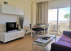 ein Wohnzimmer mit einem Sofa und einem Tisch in der Unterkunft Playa Flores Deluxe - Vistas a la piscina in Torremolinos