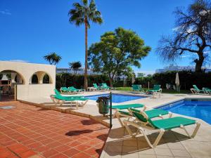 einen Pool mit Liegestühlen und einem Pool in der Unterkunft Playa Flores Deluxe - Vistas a la piscina in Torremolinos