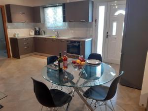 a glass table in a kitchen with a bowl of fruit at Vasiliki Residence in Pylos