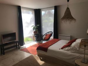1 dormitorio con 1 cama, TV y ventanas en Entre Parenthèses - Lille & Villeneuve d'Ascq en Gruson