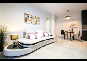 a large white couch in a room with a table at Romantic Jacuzzi Apartment in Athens