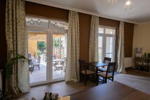 a dining room with sliding glass doors and a table and chairs at Illaberek Panzió in Eger
