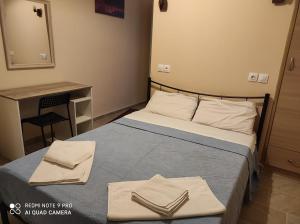 a bedroom with a bed with two towels on it at Aktaion in Milina