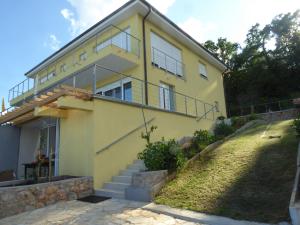 ein gelbes Haus mit Treppe davor in der Unterkunft Villa Annika in Lovran