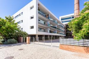 an apartment building with a fence in front of it at Fábrica Lagos - Meia Praia Flat T2 in Lagos