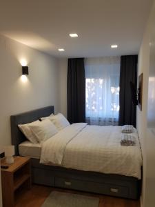 sypialnia z dużym łóżkiem i oknem w obiekcie MarSim Lux apartman Zagreb w Zagrzebiu