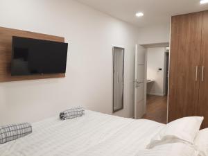 a bedroom with a bed with a flat screen tv on the wall at MarSim Lux apartman Zagreb in Zagreb