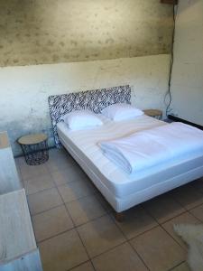 a bed with white sheets and pillows in a room at la mini ferme de maëlou in Sermaises +22 photos