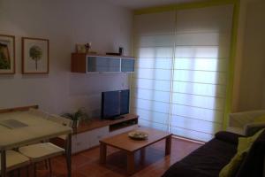 ein Wohnzimmer mit einem Sofa und einem Tisch in der Unterkunft Tresmall in Les Cases d'Alcanar