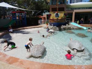 grupa dzieci bawiących się w basenie z żółwiami w obiekcie Crown Towers w mieście Gold Coast