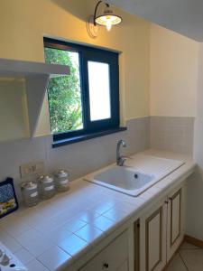 une cuisine avec un évier et une fenêtre dans l'établissement Casa Salina, à Santa Marina Salina