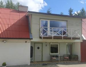 ein Haus mit einem roten Dach und einem Balkon in der Unterkunft Saadjärve Kingu talu puhkemaja in Valgma