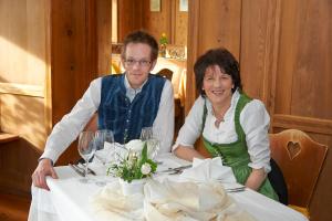 Ein Mann und eine Frau sitzen an einem Tisch in der Unterkunft Ansitz Burg Heimfels in Heinfels