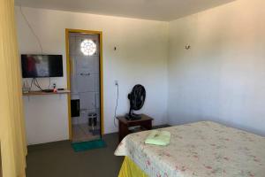 1 dormitorio con 1 cama, TV y ventana en Recanto Maristela en Grossos