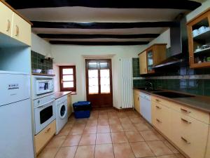 uma cozinha com um lavatório e uma máquina de lavar louça em Apartamentos LAZKANO I Y II em Huarte-Araquil