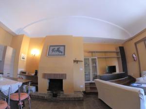 sala de estar con chimenea, mesa y sillas en Appartamento In Villa Di Judighes en Cerveteri