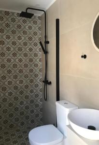 ein Bad mit einem WC, einem Waschbecken und einer Dusche in der Unterkunft Cabernet Houses in Lefkada Town