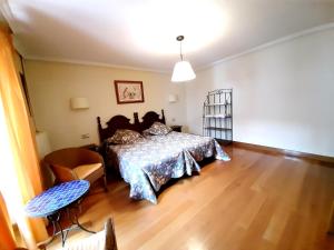 um quarto com uma cama e piso em madeira em Apartamentos LAZKANO I Y II em Huarte-Araquil