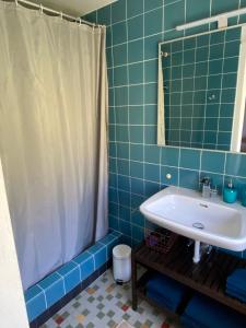 FlumserbergにあるHaus Biancaの青いタイル張りのバスルーム(シンク、シャワー付)