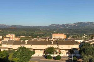 a large building in a city with mountains in the background at Apartament Comarques Catalanes in Móra d'Ebre