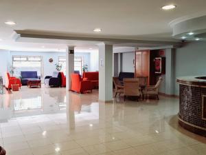 a lobby with red chairs and tables in a building at Hotel Europa in Cambados