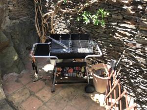 - un barbecue installé à côté d'un mur en pierre dans l'établissement Casa Jordi, à Cadaqués