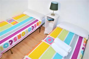 1 dormitorio con 2 camas y mesa con lámpara en Apartamento Veronica H en Málaga