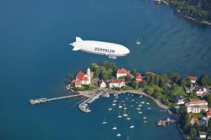 an airship is flying over a harbor with boats at CityApartments Residence klimatisiert in Friedrichshafen