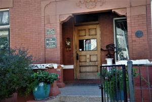 uma porta da frente de um edifício de tijolos com um sinal nele em Off Broadway B & B em Denver