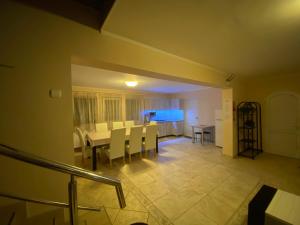 a dining room with a table and white chairs at Vila Eszter in Sovata