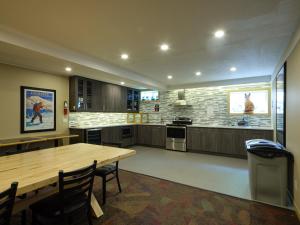 a large kitchen with a wooden table and chairs at Fernie Fox Hotel in Fernie