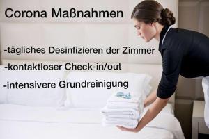 Eine Frau legt Handtücher auf ein Bett in der Unterkunft Hotel West in Hamburg