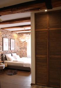 a bedroom with a bed and a brick wall at Apartamenty Luizjana in Toruń