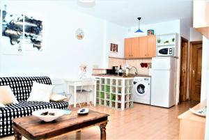 a kitchen and living room with a couch and a table at Apartamento Veronica in Málaga