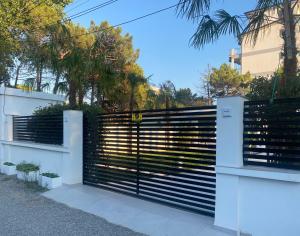 una puerta en una valla delante de una casa en White Beach Villa 1 - Luxury en Velipojë