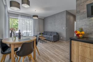 uma cozinha e sala de estar com uma mesa e um sofá em Apartament K2 Pułaskiego 1 em Toruń