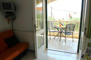a living room with a door open to a patio with a table at Apartments Marin in Bol